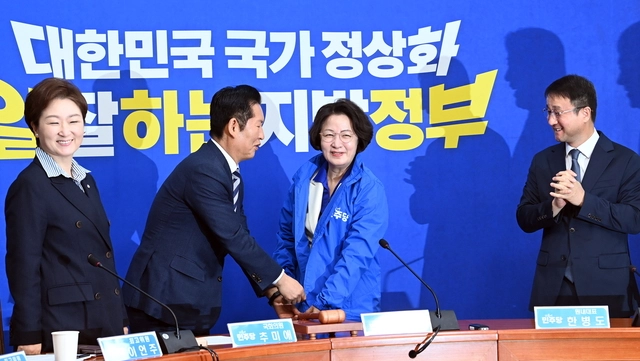정청래(왼쪽 두 번째)더불어민주당 대표가 13일 오전 국회에서 열린 추미애경기도지사후보 환영식에서 추후보자에게 당점퍼를 입혀주고 있다. 곽성호기자