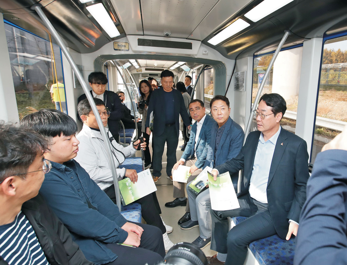 정명근(오른쪽 첫 번째) 경기 화성시장이 지난 2024년 10월 16일 한국철도기술연구원 오송 분원을 방문해 동탄에 설치될 트램에 탑승, 관계자로부터 설명을 듣고 있다.  화성시청 제공