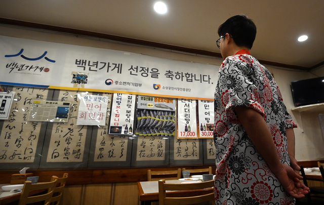 53년 동안 영업하다 오는 5월 문을 닫는 신성일식 매장 안에서 9일 매장 관계자가 백년가게 선정 당시 받은 축하 플래카드를 씁쓸하게 바라보고 있다.  박윤슬 기자