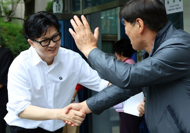 한동훈 전 국민의힘 대표가 14일 오후 부산 북구 만덕2동 행정복지센터를 찾아 전입신고를 마친 뒤 주민과 인사하고 있다. 연합뉴스