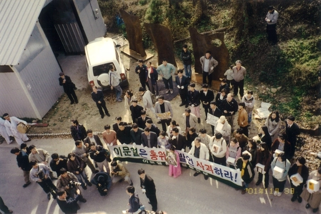 지난 2001년 경기 이천 이문열 작가 집 앞에서 열린 책 장례식 장면. 피켓을 든 어른들 앞에서 한 소녀가 영정을 들고 서 있다.  ⓒ이재유
