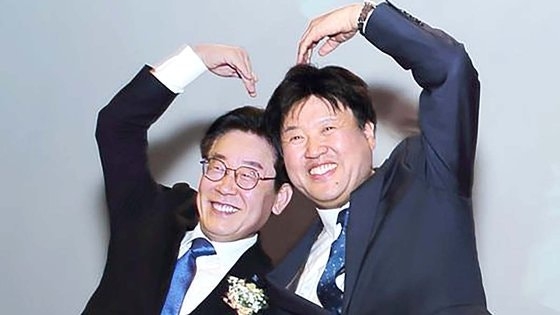 2019년 12월 당시 경기지사였던 이재명 대통령(왼쪽)과 경기도 대변인이었던 김용 전 민주연구원 부원장이 판교에서 열린 ‘김용의 북콘서트’에 참석해 손 하트를 하며 사진을 찍고 있다. 김용 전 부원장 블로그 캡처