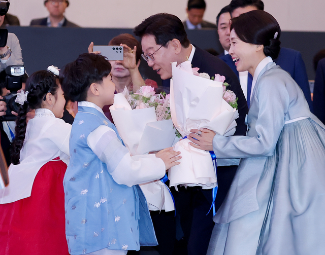베트남을 국빈 방문 중인 이재명 대통령과 김혜경 여사가 22일(현지시간) 하노이의 한 호텔에서 열린 동포간담회에서 화동으로부터 꽃다발을 받고 있다. 연합뉴스