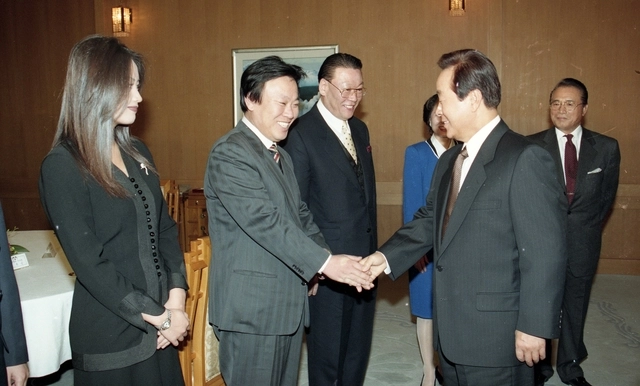 1995년 김영삼 대통령이 작가 이문열과 악수를 하고 있다. 왼쪽은 배우 김혜수.  연합뉴스