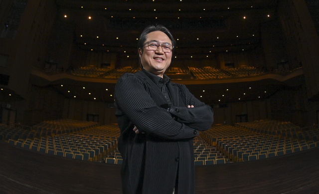 박성호 경기리베라오케스트라 지휘자가 지난 6일 경기 수원시 팔달구 일원 경기아트센터 대극장 무대에서 객석을 배경으로 포즈를 취하고 있다. 그가 선 자리에서 오는 16일 경기리베라오케스트라의 제2회 정기연주회 ‘봄의 소동’이 막을 올린다.   백동현 기자