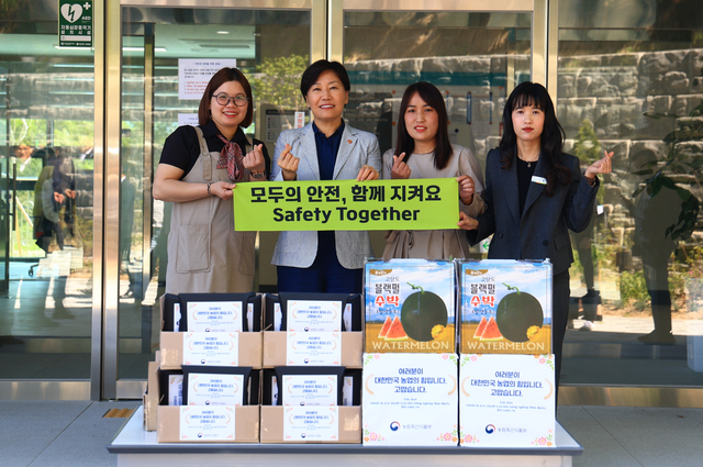 송미령(왼쪽에서 두번째) 농림축산식품부  장관이 8일 전북 임실군에서 베트남 국적의 공공형 계절근로자들에게 기념 수건과 수박 등을 전달하며 기념촬영하고 있다. 농림축산식품부 제공