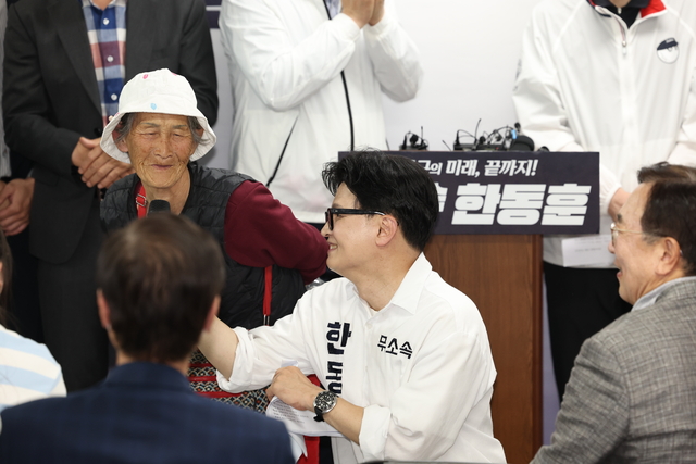 한동훈 무소속 부산 북구갑 보궐선거 후보가 10일 부산 북구 선거 캠프에서 열린 선거 사무소 개소식에서 찰밥 할머니를 소개하고 있다.  뉴시스