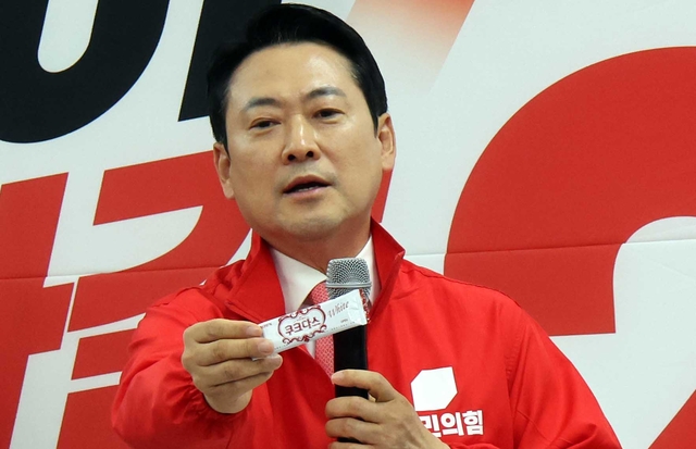장동혁 국민의힘 대표가 14일 세종시장 선거에 출마한 최민호 후보의 선대위 출범식에 참석해 쌍방울 대북송금 수사 과정에서 ‘검사의 연어 술파티 회유’ 등 각종 의혹이 제기 됐으나 실제는 과자를 제공한 게 다였다고 말하며 해당 과자를 들어보이고 있다. 연합뉴스