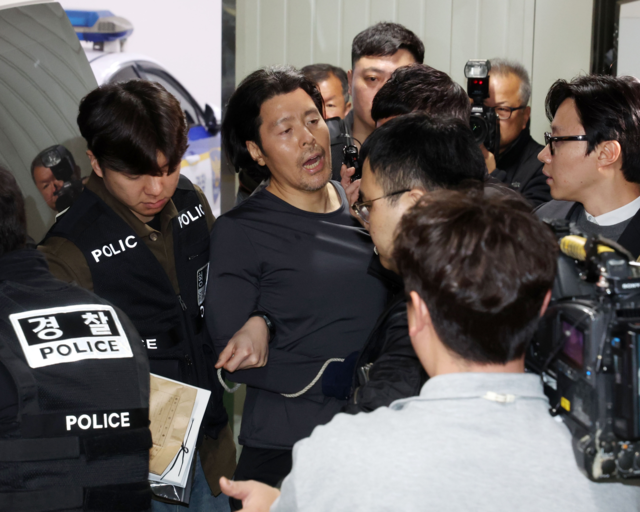항공사 기장을 살해한 혐의로 구속된 김동환이 지난달 26일 부산 부산진경찰서에서 호송차량에 오르며 취재진에게 자신의 입장을 밝히고 있다. 뉴시스