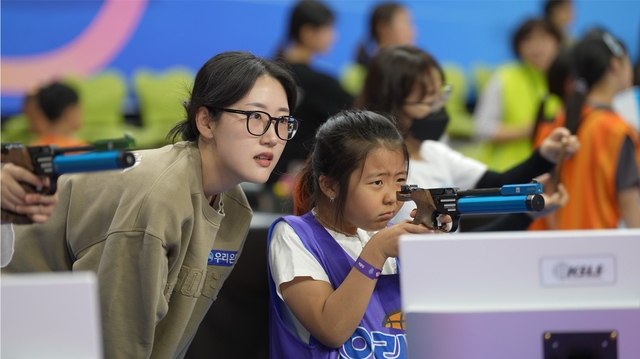 양지인 사격 국가대표 선수가 지난 5일 인천 송림체육관에서 열린 ‘우리 드림 스포츠데이’에서 참가 아동들의 사격 연습을 지도하고 있다. 우리금융그룹