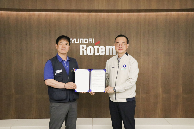 김익수(오른쪽) 현대로템 경영지원본부장과 남봉희(왼쪽) 전국금속노동조합 현대로템 지회장이 지난 19일 현대로템 창원공장에서 열린 동반성장 노사미래전략TFT 발족식에서 기념촬영하고 있다. 현대로템 제공