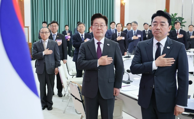 이재명 대통령이 21일 오전 청와대에서 열린 대통령 자문회의·위원회 간담회에서 국민의례를 하고 있다. 이 대통령 뒤쪽 오른편에 이석연 국민통합위원장이 보인다. 연합뉴스