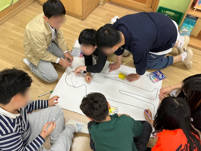 지난해 서울 영등포구 한 초등학교에서 진행된 영등포종합사회복지관의 아동사회문제해결 선도사업 ‘마음성장교실 마인드업’ 프로그램에 참여한 교사와 학생들이 ‘감정과 신체 변화 이해하기’ 활동을 하고 있다.  초록우산 제공