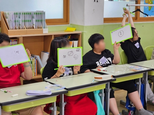 지난해 마음성장교실 마인드업 프로그램에 참가한 어린이들이 ‘친구 감정 퀴즈’를 풀고 있는 모습.  초록우산 제공