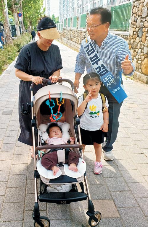 김부겸(오른쪽) 후보가 1일 대구 달서구 이곡동에서 유모차를 끌고 가는 주민과 대화하고 있다.