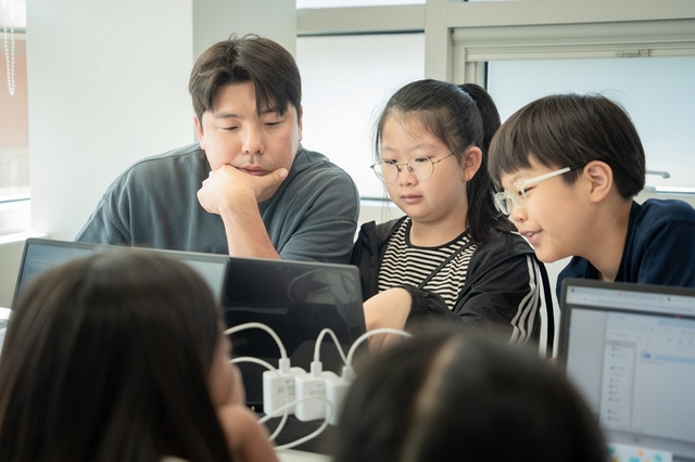 지난 4일 서울 용산구 효창동 효창사회복지관에서 CJ올리브네트웍스 임직원이 초등학생을 대상으로 AI 활용 교육 봉사 프로그램을 진행하는 모습. CJ올리브네트웍스 제공