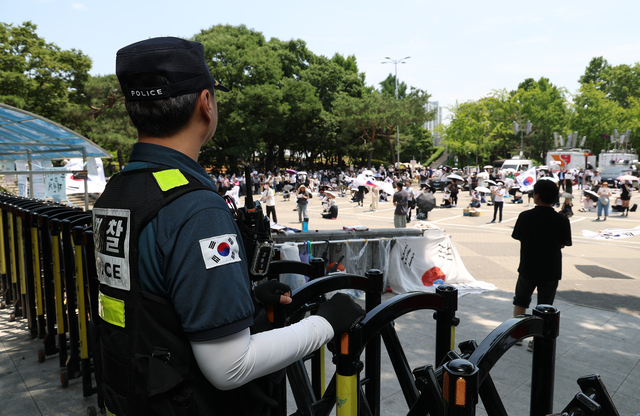 6·3 지방선거 투표용지 부족 사태를 규탄하며 재선거를 요구하는 ‘잠실 개표소 봉쇄 시위’가 계속되고 있는 9일 서울 송파구 올림픽공원 핸드볼경기장 출입구 앞을 경찰이 지키고 있다. 연합뉴스