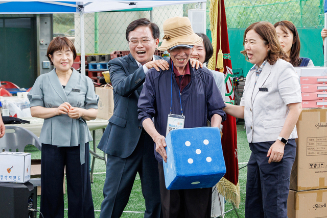 진교훈(왼쪽 두 번째) 강서구청장이 9일 강서구장애인게이트볼장에서 열린 ‘강서구장애인단체총연합회 힐링 워크숍’에 참석해 주사위 던지기 참가자의 어깨를 주무르며 응원하고 있다. 강서구청 제공