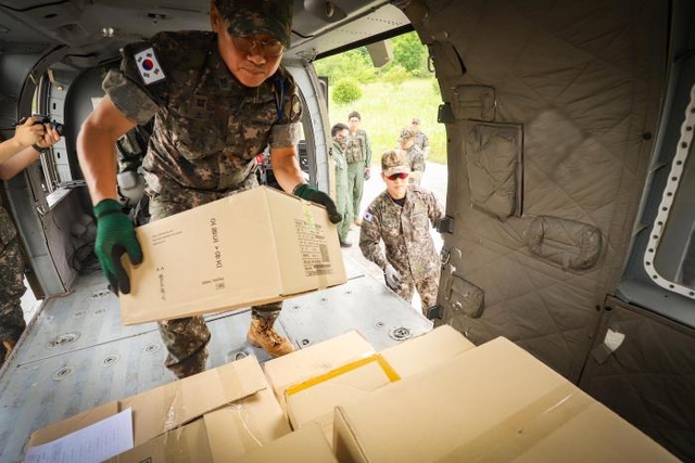 육군 35보병사단 보급수송근무대 김종희 추진보급소대장이 지난 9일 열린 공중보급 중 KUH-1 수리온 헬기에 보급물자를 적재하고 있다. 육군 제공/국방일보