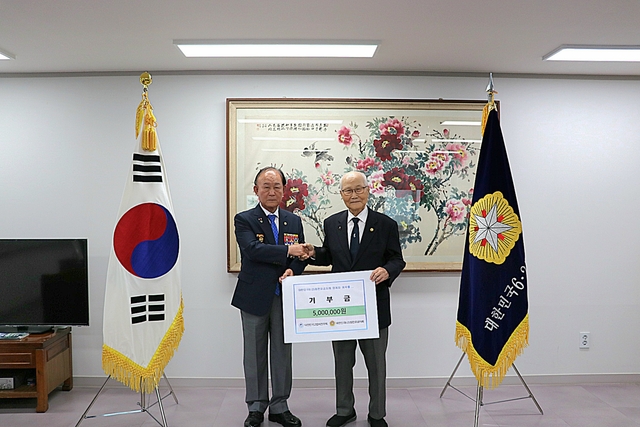 김길래(왼쪽) 대한민국고엽제전우회 회장이 11일 서울 강동구 6·25참전유공자회를 찾아 손희원(오른쪽) 회장에게 기부금 500만원을 전달한 뒤 기념촬영하고 있다. 고엽제전우회 제공
