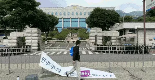 ‘민주주의 꽃은 매진입니다’ 현수막 거는 이제석 대표. 연합뉴스