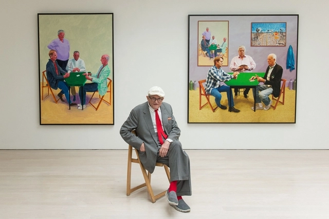 데이비드 호크니가 2015년 5월 런던에서 열린 ‘회화와 사진’ 전시에서 자신의 작품 ‘카드놀이 하는 사람들 #3’(왼쪽)과 ‘더 큰 카드놀이 하는 사람들’ 사이에 앉아있다. AFP 연합뉴스