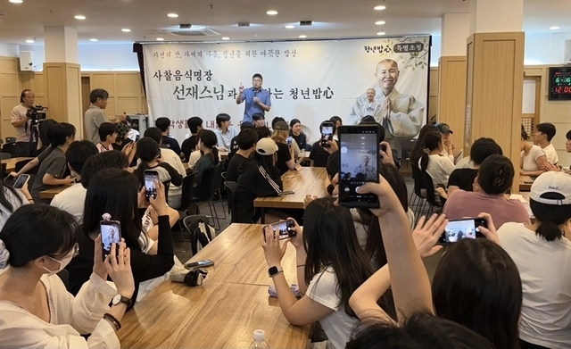 16일 서울 연화사에서 열린 ‘청년밥심’에서 이날 행사에 대해 설명하고 있는 유철주 조계종 사회복지재단 홍보위원(맨 앞 왼쪽)과 선재스님. 학생들이 선재스님의 사진을 찍고 있다.  박동미 기자