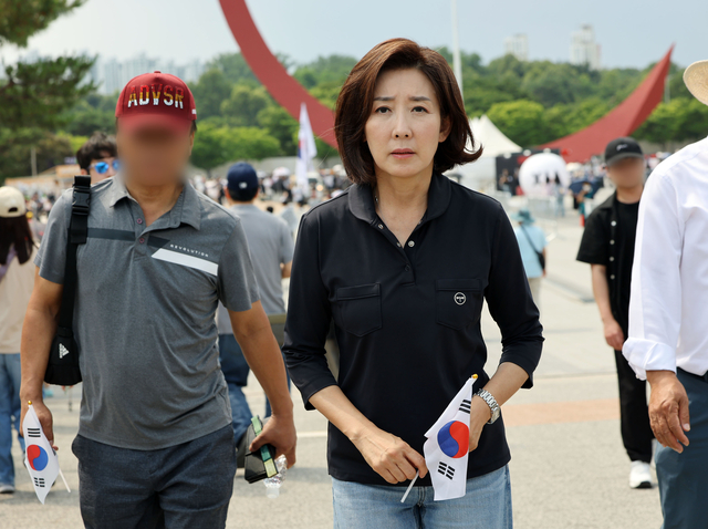 14일 국민의힘 나경원 의원이 6·3 지방선거 투표용지 부족 사태를 규탄하는 ‘개표소 봉쇄 시위’가 이어지고 있는 서울 송파구 올림픽공원 핸드볼경기장을 찾아 태극기를 들고 이동하고 있다. 연합뉴스