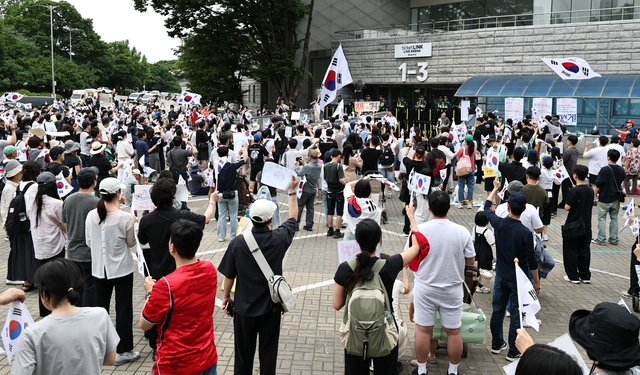 지난 7일 서울 송파구 올림픽공원 핸드볼경기장 앞에서 참정권 시위에 참석한 시민들이 구호를 외치고 있다.  연합뉴스