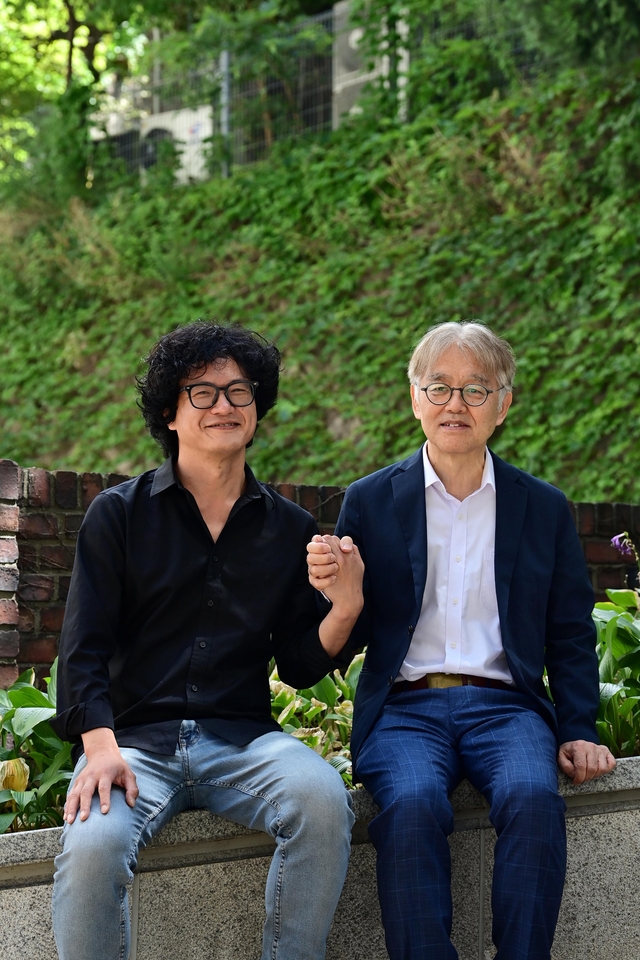 연극 ‘113’의 희곡을 쓴 최재경(오른쪽) 전 고등과학원장과 연출을 한 김제민 리멘워커 대표가 지난달 26일 문화일보 사옥 앞에서 손을 잡고 있다.  문호남 기자
