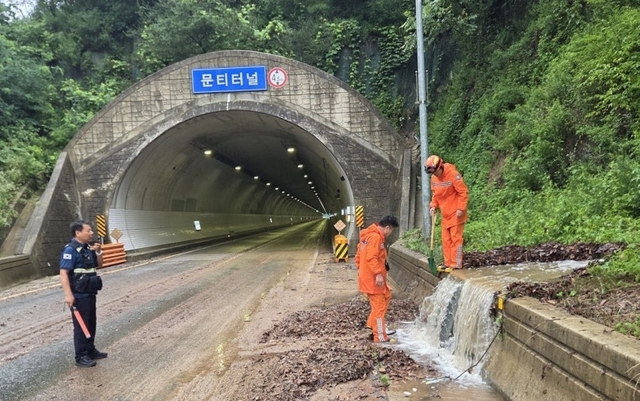 9일 오전 충북 옥천군 안내면 방하목리 문티터널 인근에서 소방대원들이 폭우로 쓸려 내려온 토사에 막힌 배수구를 뚫고 있다. 옥천소방서 제공
