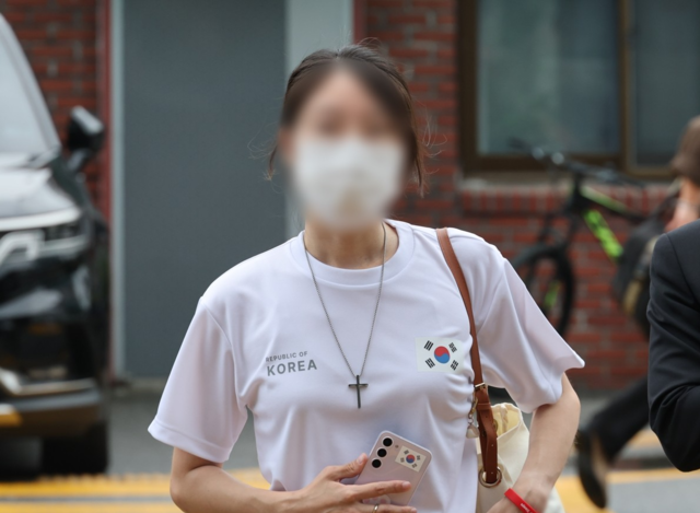 잠실 올림픽공원 핸드볼경기장 문 앞에서 체육단체 직원 등의 장내 사무실 진입을 막아 업무 방해 혐의를 받는 30대 여성 A 씨가 10일 송파경찰서에 출석하고 있다. 강성 보수 커뮤니티에서는 이 여성을 두고 ‘올다르크’(올림픽공원+잔다르크)라 이름을 붙였다. 연합뉴스
