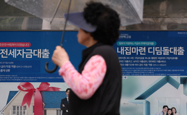 지난 9일 서울 한 은행에 붙은 대출 안내문 앞으로 한 시민이 지나가고 있다. 연합뉴스
