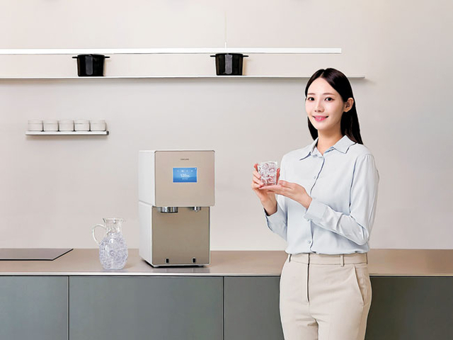 삼성전자 모델이 인공지능(AI) 자동 살균 기능을 탑재한 ‘비스포크 AI 얼음정수기’에서 나온 얼음물을 들고 정수 기능을 소개하고 있다.  삼성전자 제공