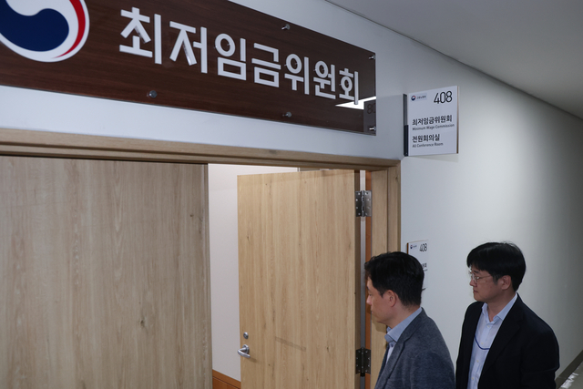 최저임금위원회 제14차 전원회의가 열린 14일 정부세종청사 최저임금위원회에서 위원들이 회의가 정회된 뒤 속개하자 전원회의장으로 들어가고 있다. 연합뉴스