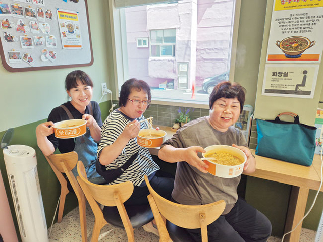 지난해 9월 초록우산 부산종합사회복지관의 부산 동구 주민조직화 사업 공간 ‘끼리라면’에서 주민들이 라면을 먹기 전 포즈를 취하고 있다. 초록우산 제공
