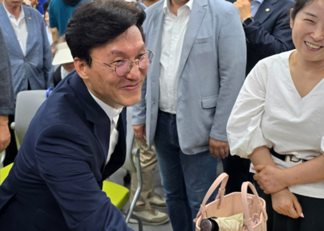 더불어민주당 당권주자인 김민석 전 국무총리가 19일 오후 민주당 부산시당에서 열린 부산 권리당원 간담회에서 참석자들과 인사하고 있다. 연합뉴스