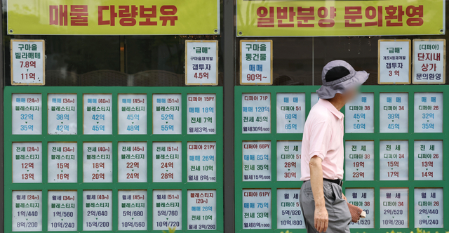 정부의 부동산 세제개편안 발표를 앞둔 31일 서울 강남구 한 부동산중개업소 매물판 앞으로 한 시민이 걸어가고 있다. 연합뉴스