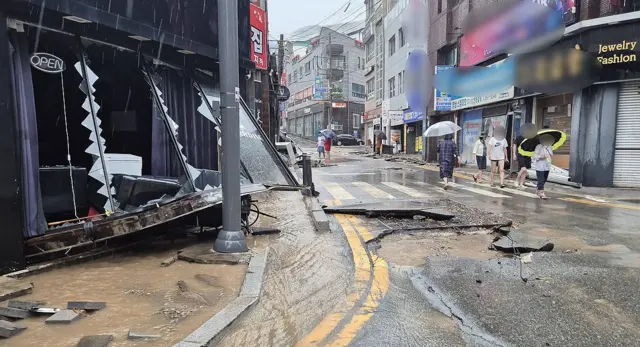 17일 오전 경남 거제시 옥포동 한 상가 일대에서 집중호우로 점포 유리창이 깨지고 도로 아스팔트가 뜯겨 나가는 등 피해가 발생했다. 연합뉴스