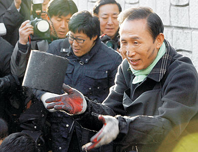 지난해 11월 대통령 선거 당시 한나라당 대선 후보로 경기 고양시 토당동에서 불우이웃에게 연탄을 배달하는 행사에 참석한 이명박(오른쪽) 대통령.