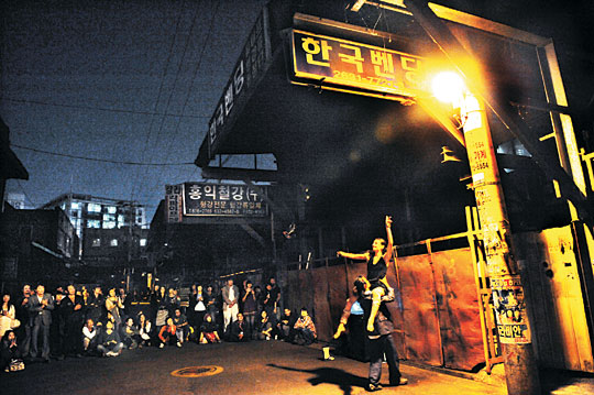 부부 춤꾼인 에오시 무용단의 김봉호, 셀린 바께가 철재상가 가로등 밑에서 즉흥행위 예술을 하고 있다.