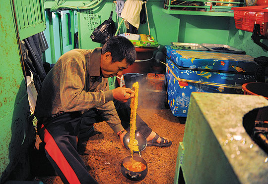 비좁은 선내 조리실에서 배고픔을 덜기 위해 간식으로 라면을 끓여 먹고 있다.