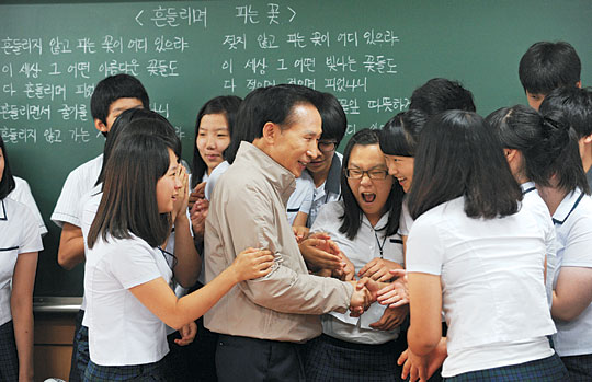 이명박 대통령이 24일 기숙형 고등학교인 충북 괴산군 괴산고를 방문, 학생들에게 둘러싸여 인사하고 있다.