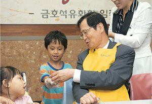 박찬구(오른쪽) 금호석유화학 회장이 장애인 재활원을 찾아 아이들과 송편 만들기를 하고 있다.