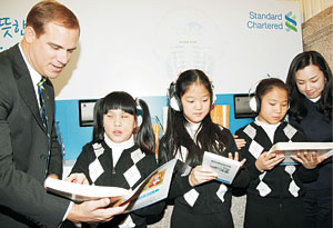 리처드 힐(왼쪽) 스탠다드차타드금융지주 대표가 시각장애 어린이들과 함께 오디오북을 듣고 있다.