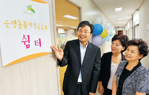 김우영(왼쪽) 서울 은평구청장이 지난 9일 녹번동 ‘은평 돌봄 여성근로자 쉼터’ 개소식에서 참석자들과 현판을 보며 대화를 나누고 있다.