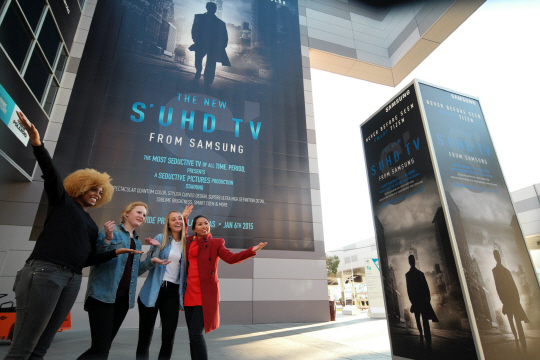 ‘CES 2015’ 개막을 앞둔 5일 미국 라스베이거스 컨벤션센터 앞에 설치된 삼성전자 퀀텀닷(SUHD) TV 광고판 앞에서 직원들이 포즈를 취하고 있다.