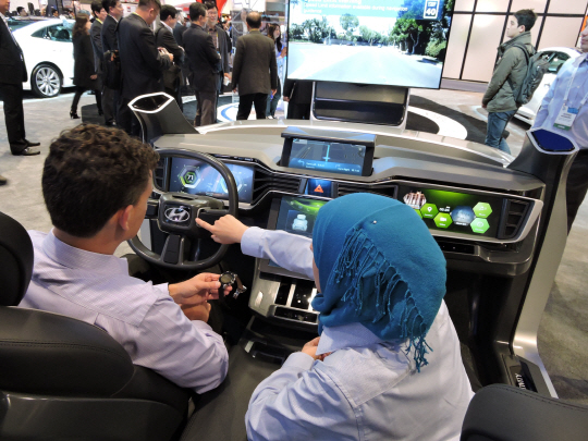 8일 미국 라스베이거스 컨벤션센터에서 열린 세계 최대 가전전시회 ‘CES 2015’의 현대자동차 전시관에서 한 직원이 관람객에게 3차원의 동작 인식 기술 등을 구현한 미래형 인포테인먼트(정보와 오락의 합성어) 차량을 시연해 보이고 있다.