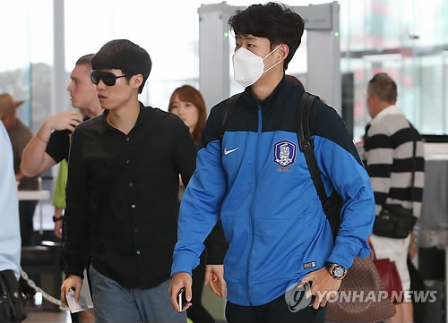 (캔버라=연합뉴스) 감기에 걸려 2015 호주 아시안컵 조별리그 2차전 쿠웨이트와 경기에 나서지 못했던 손흥민(레버쿠젠)이 3차전 장소인 브리즈번으로 이동을 위해 14일 호주 캔버라 국제공항에 마스크를 쓴 채 들어서고 있다. 왼쪽이 박지성.