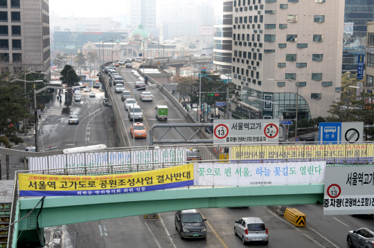 서울역 고가도로 옆면에 ‘서울역 고가도로 공원화 사업’ 반대 의견을 담은 현수막과 찬성 입장을 밝힌 현수막이 19일 나란히 걸려 있다.  김동훈 기자dhk@